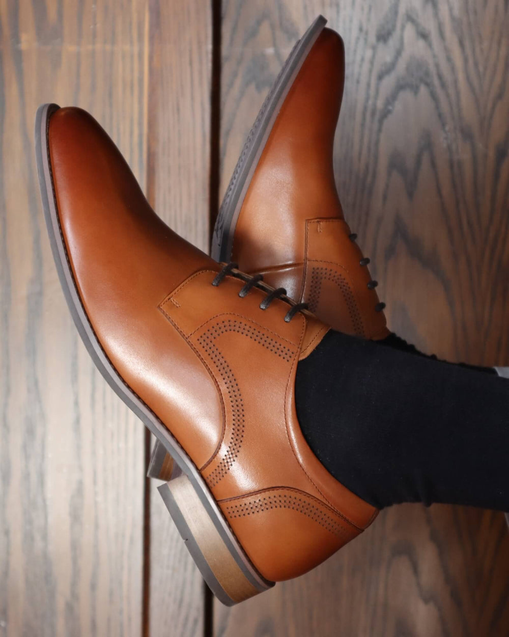 Brown leather dress shoes on a wooden floor
