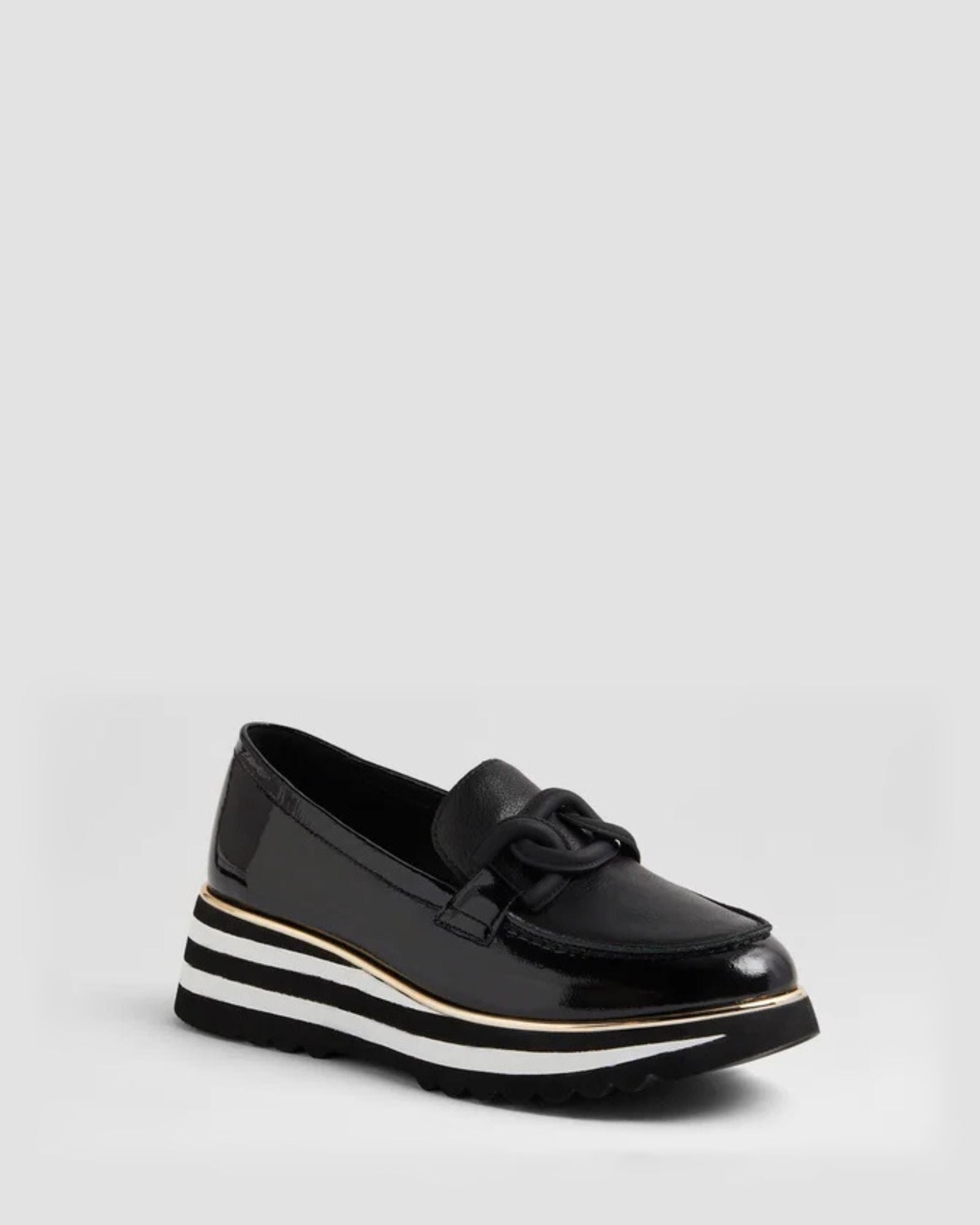 Black patent leather loafer with a white sole on a light gray background