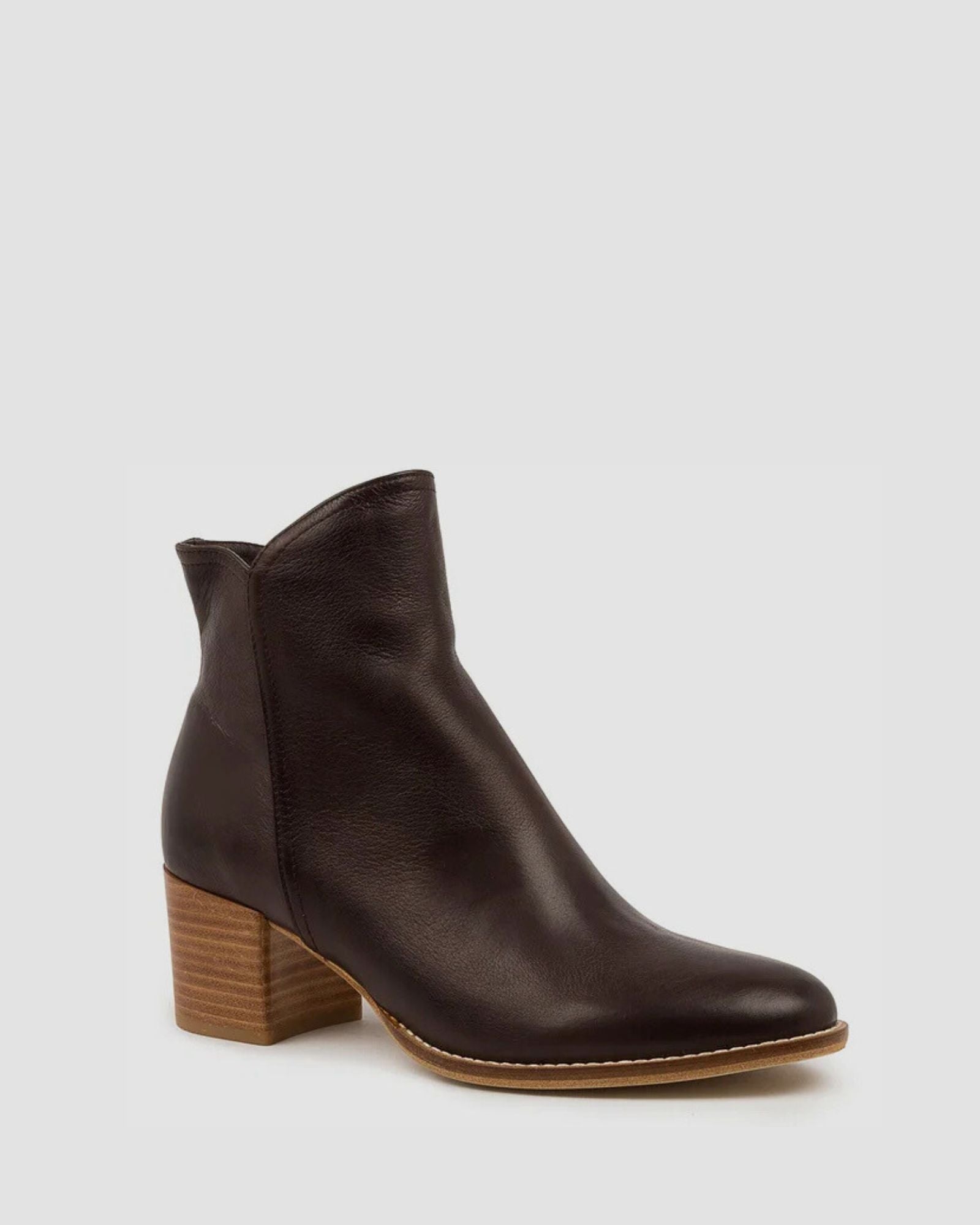 Brown ankle boot with a wooden heel on a light gray background